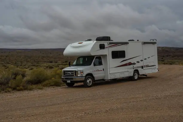 C-type camper with slideouts standing in the desert with prarie in the background