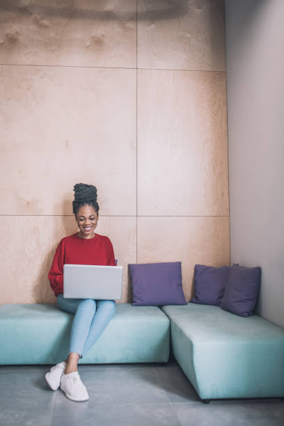 istock Young black woman sitting and working on a laptop 1317638928