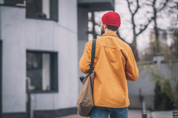istock Man in an orange jacket walking down the street 1317639968