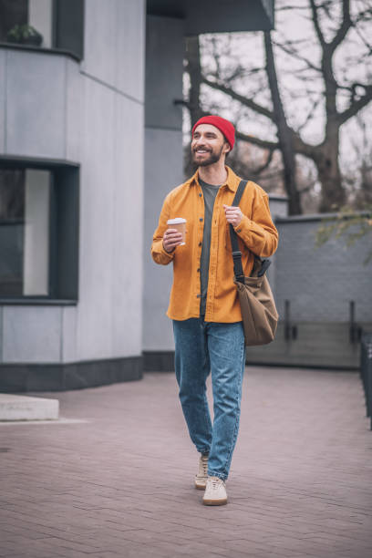 istock Man in an orange jacket walking down the street 1317639977