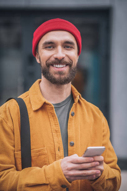istock Man in a red hat and orange jacket looking happy 1317640016