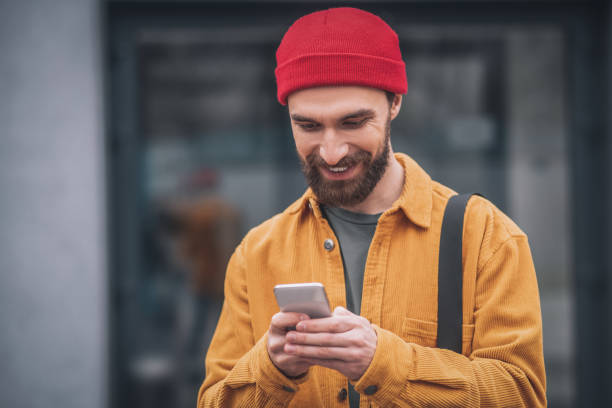 istock Man in a red hat and orange jacket looking happy 1317640037
