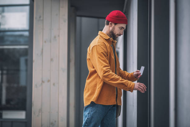 istock Bearded young man opening the door with an access card 1317640090