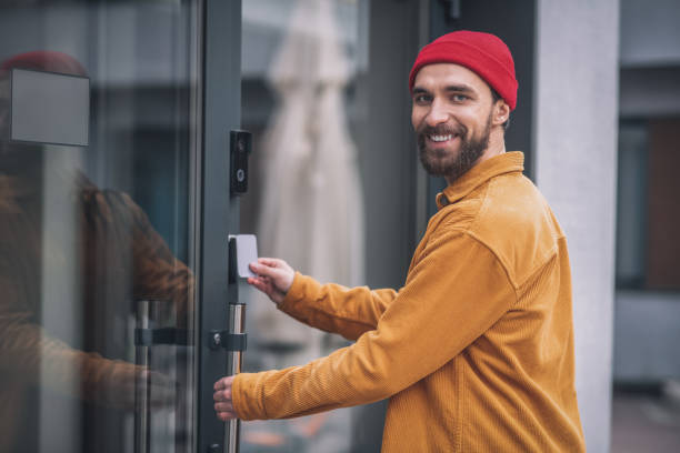 istock Bearded young man opening the door with an access card 1317640122