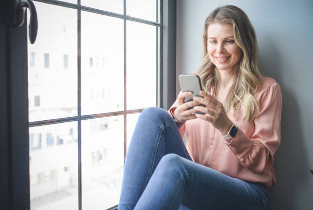 istock attractive middle aged woman in the office ( mobile phone) 1317640381