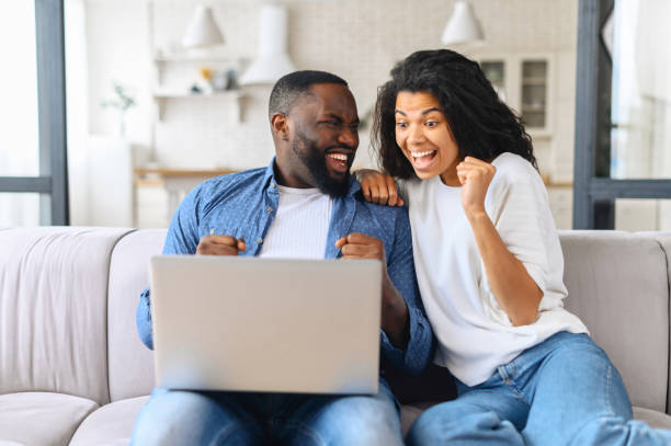 istock Hilarious African-American couple using laptop at home 1317641178