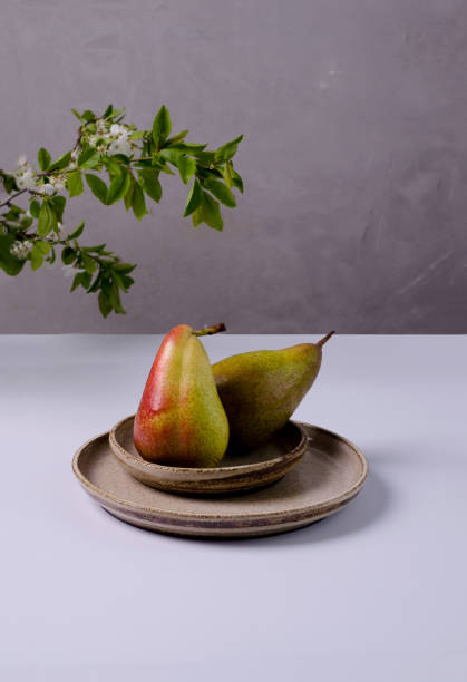 istock Red-green pears lie in a ceramic plate, selective focus, copying space 1317641837