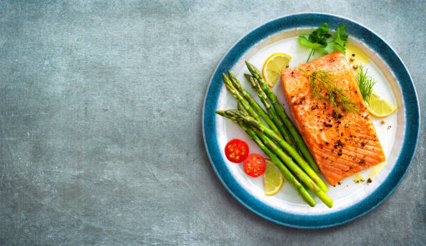 istock Grilled salmon steak garnished with green asparagus, lemon and tomatoes 1317641940