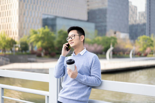 istock An Asian man using mobile phone to make a call with coffee in downtown district 1317641992
