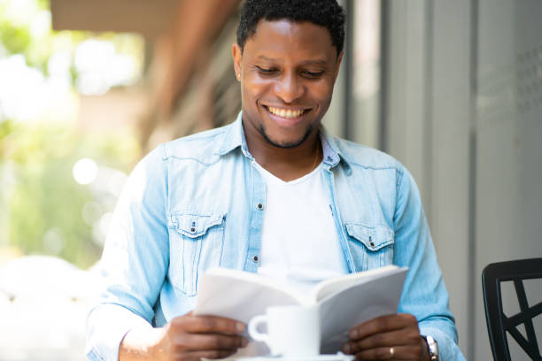istock Man reading a book at coffee shop. 1317642562