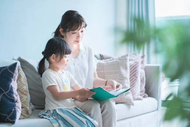 istock Mother and daughter reading a picture book 1317649902