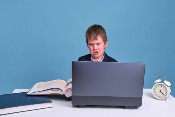 istock Angry junior in a school uniform at a laptop during online training 1317650520