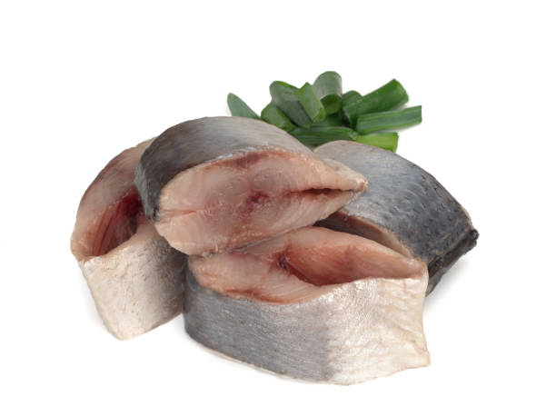 Lightly salted Norwegian herring with fresh green onions, isolated on white background.