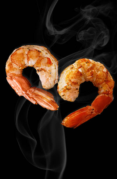 due code di gamberetti alla griglia a forma di cuore in foschia bianca su nero - grilled shrimp foto e immagini stock