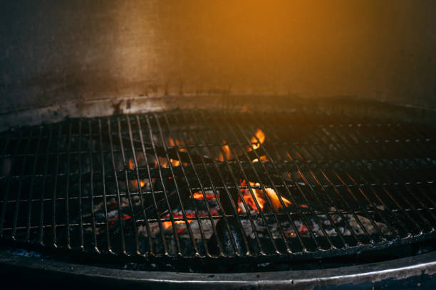 istock Empty hot charcoal barbecue grill with flame on black background 1317652180