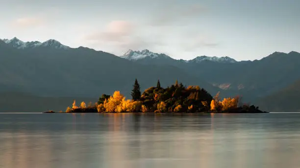 Autumn Ruby Island lit by the setting Sun at Lake Wanaka, Otago region, South Island, New Zealand