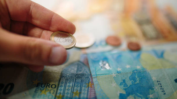 mano con in mano una moneta da 1 euro e banconote - european union coin one euro coin one euro cent coin foto e immagini stock
