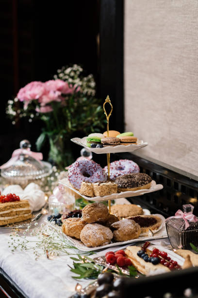 istock donut in colored glaze multicolored macaroons on a multi-tiered plate next to other desserts 1317657616