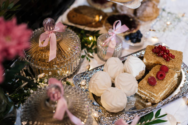 istock marshmallows and cakes decorated with red currants and fresh raspberries on a silver tray. there are beautiful crystal jars with pink ribbons nearby 1317657640