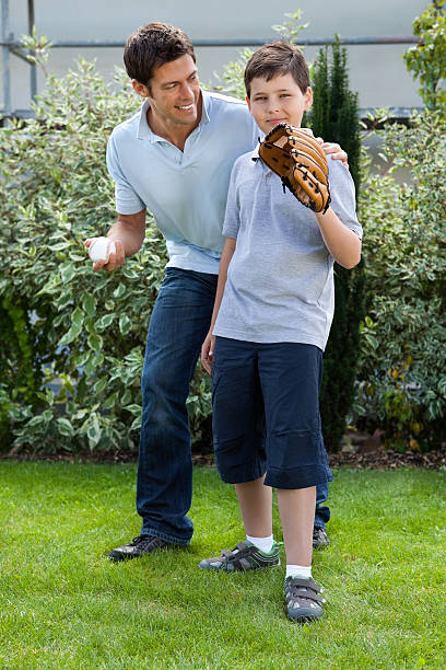 istock Cute little boy playing baseball with his father 131765829