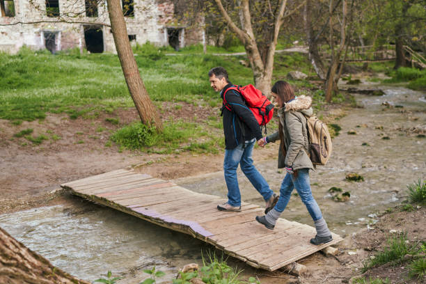 istock Hikers couple crossing a small bridge over a river 1317662404