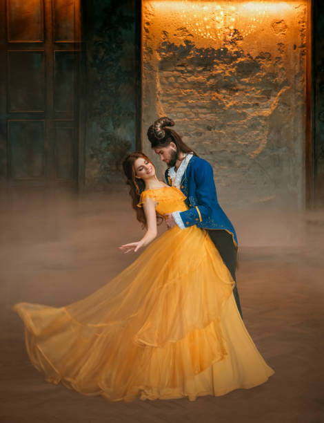 loving couple is dancing at fairy ball. Happy beauty woman fantasy princess in yellow dress and guy is enchanted guy, horns on head Girl whirls in arms of male prince. Man monster carnival costume pareja amorosa está bailando en la bola de hadas. feliz belleza mujer princesa de fantasía en vestido amarillo y el tipo es un tipo encantado, cuernos en la cabeza chica gira en los brazos del príncipe masculino. traje de carnaval monstruo hombre.