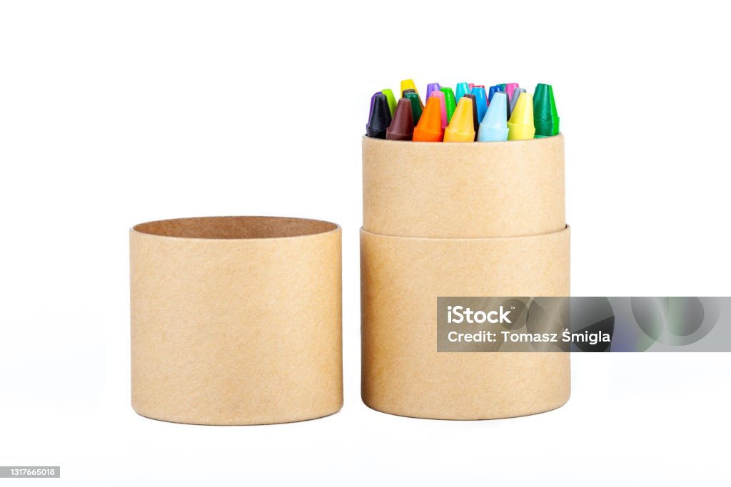 Colorful thin wax crayons set in an open eco friendly brown paper tube packaging, simple crayon paper box object isolated on white, cut out. School supplies, drawing accessories, education, creativity Crayon Stock Photo