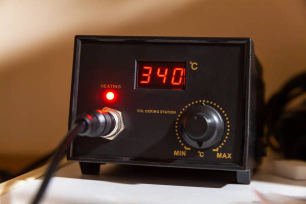 Simple soldering station box turned on, heated to 340 degrees celsius, front panel digital display visible. Heating soldering equipment, electrician's work tools concept