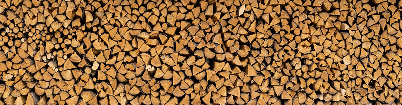 Beautiful stack of brown firewood - panoramic detail on a farm