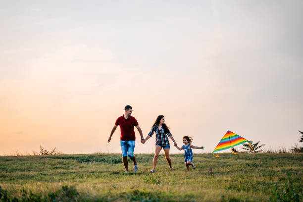 istock Family playing with kite on meadow 1317667418