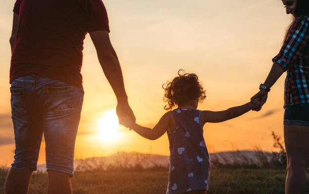 istock Little girl and her parents watching sunset 1317667779