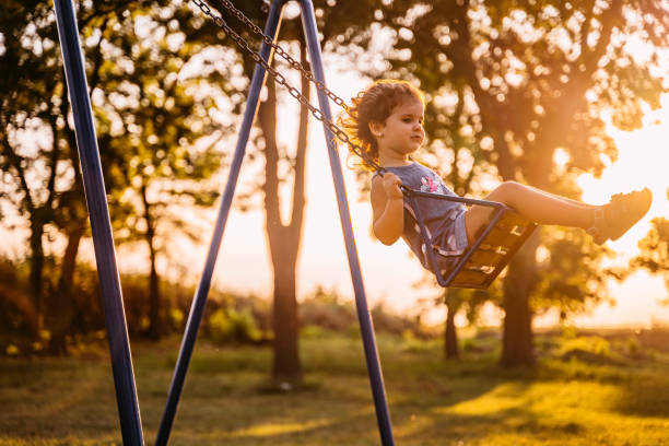 istock Little girl swinging at sunset 1317667902