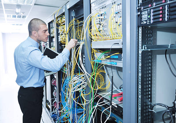 istock businessman with laptop in network server room 131766935