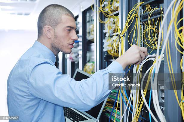 Hombre De Negocios Con Ordenador Portátil En La Sala De Servidores De Red Foto de stock y más banco de imágenes de Hombres