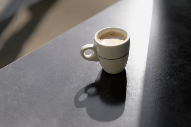 istock a cup of coffee with shadows on gray backgound 1317670332