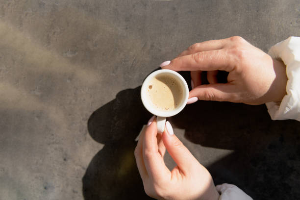 新鮮なコーヒーを飲みながら、朝のコンセプトを持つ女性の手 - コーヒー　淹れる ストックフォトと画像