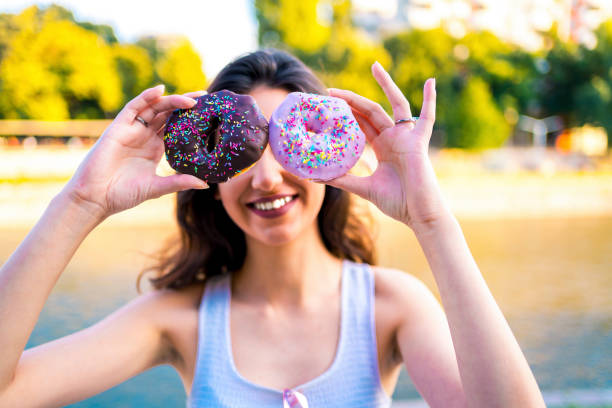 istock Woman having fun with donuts 1317672211