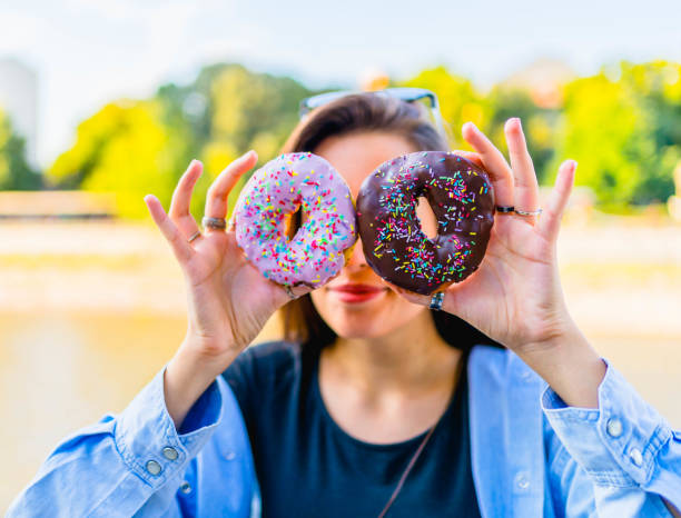 istock Woman having fun with donuts 1317673760