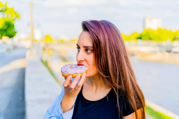 istock Woman eating a doughnut 1317673795
