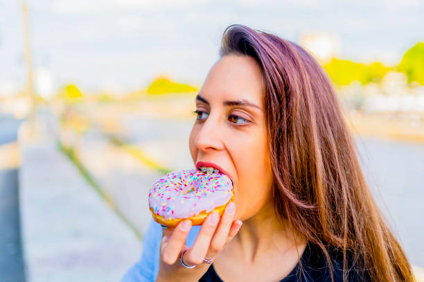istock Woman eating a doughnut 1317673844