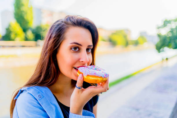 istock Woman enjoying eating donut 1317674612