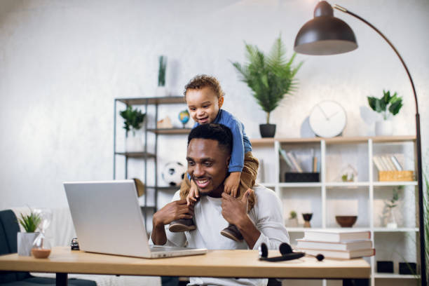 istock African father with cute son on neck working on laptop 1317675601