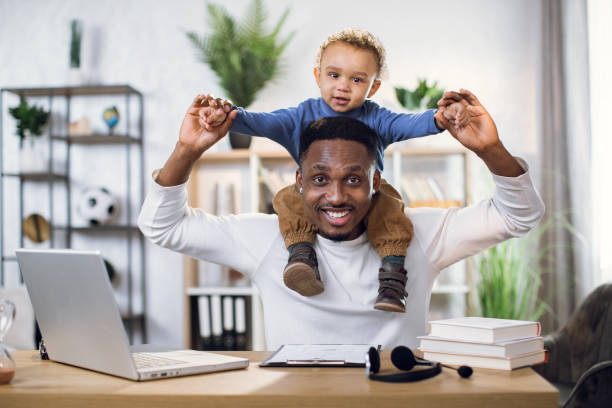 istock Afro american father with son on neck working from home 1317675647