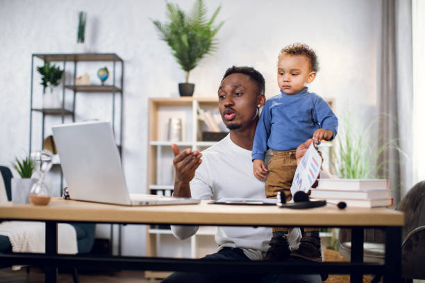 istock African businessman working from home with son on hands 1317675659