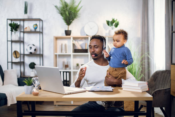 istock Young man having video conference while taking care of son 1317675670