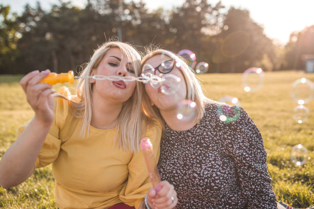 istock Best friends making soap balloons in the park 1317675736