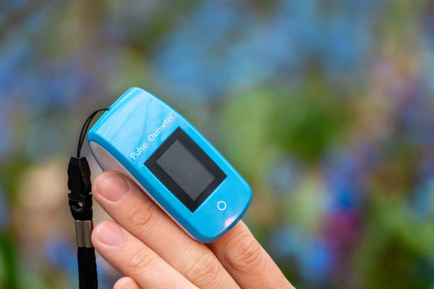 istock Pulse oximeter on finger close-up in blue flowers 1317675778