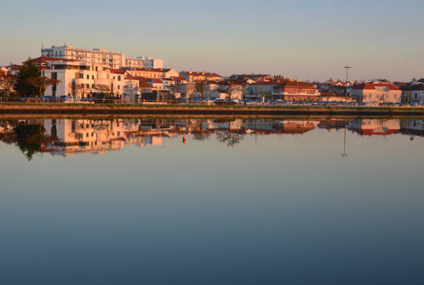 Moita, Setúbal district, Portugal: waterfront at sunset, view along the local corniche, the Avenida Marginal, with the Town Hall on the left (Camara Municipal da Moita) - skyline reflection on the Tagus River - Moita do Ribatejo, riverside town in the Lisbon area