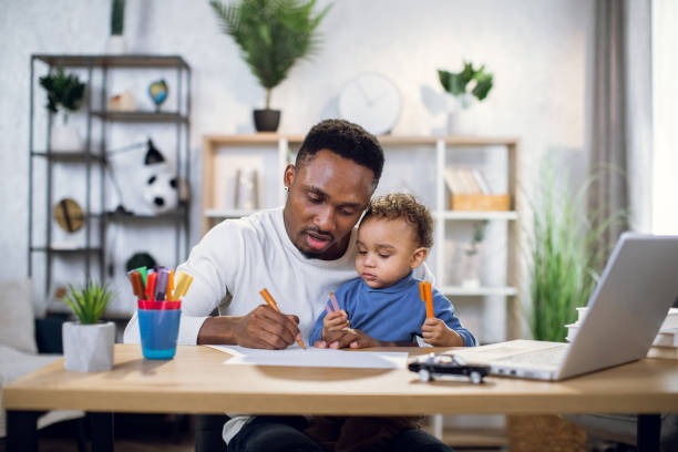 istock Afro american man carrying son and working on laptop 1317675881
