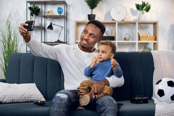 istock Happy father and son taking selfie on smartphone at home 1317676061